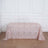 Rose gold sequin tablecloth with floral pattern on a wooden floor.