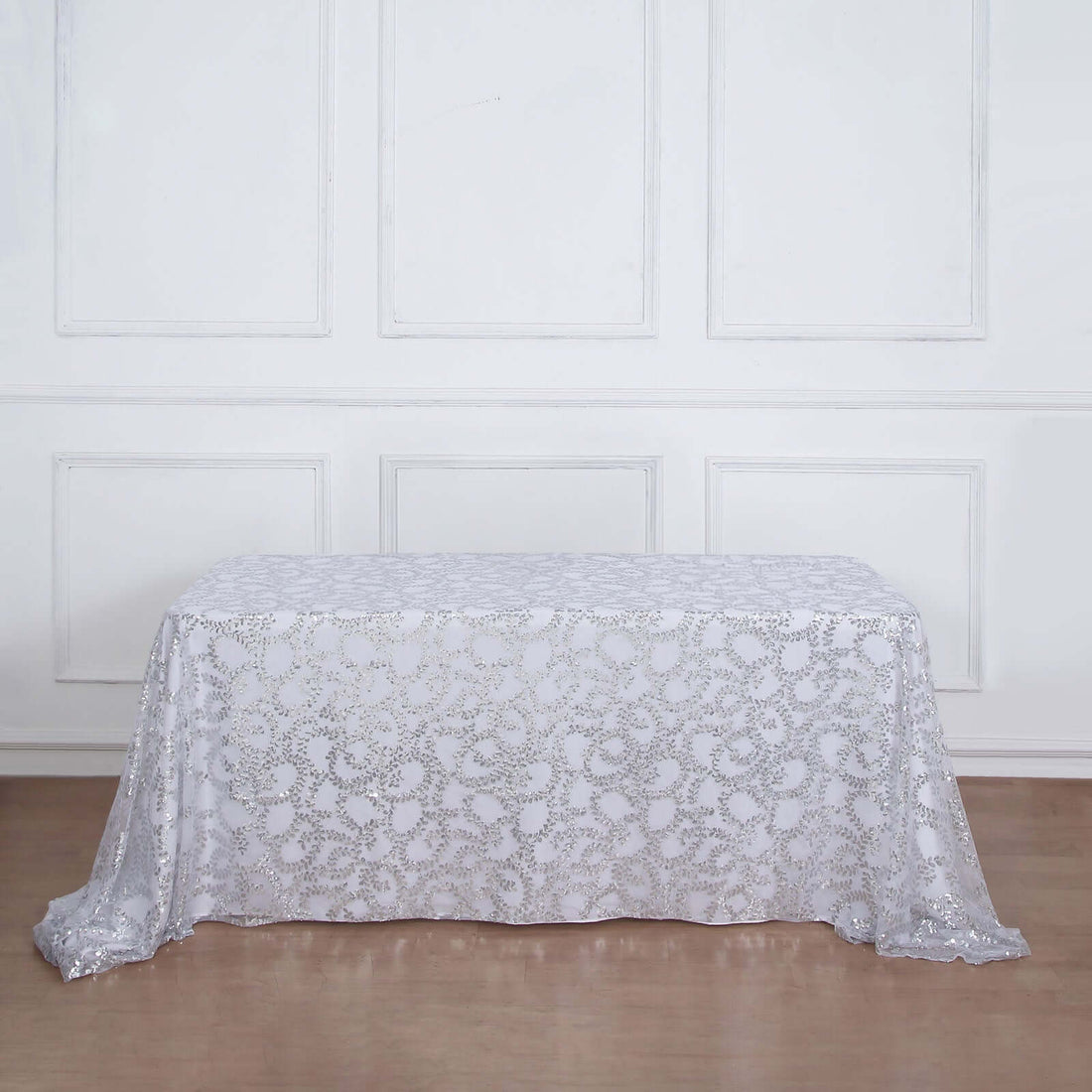 White lace tablecloth draped over a table in a studio setting.