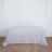 White lace tablecloth draped over a table in a studio setting.