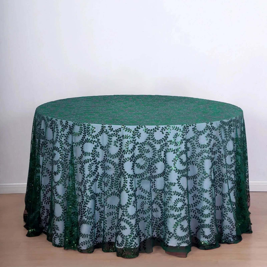 Round green floral tablecloth on a circular table.