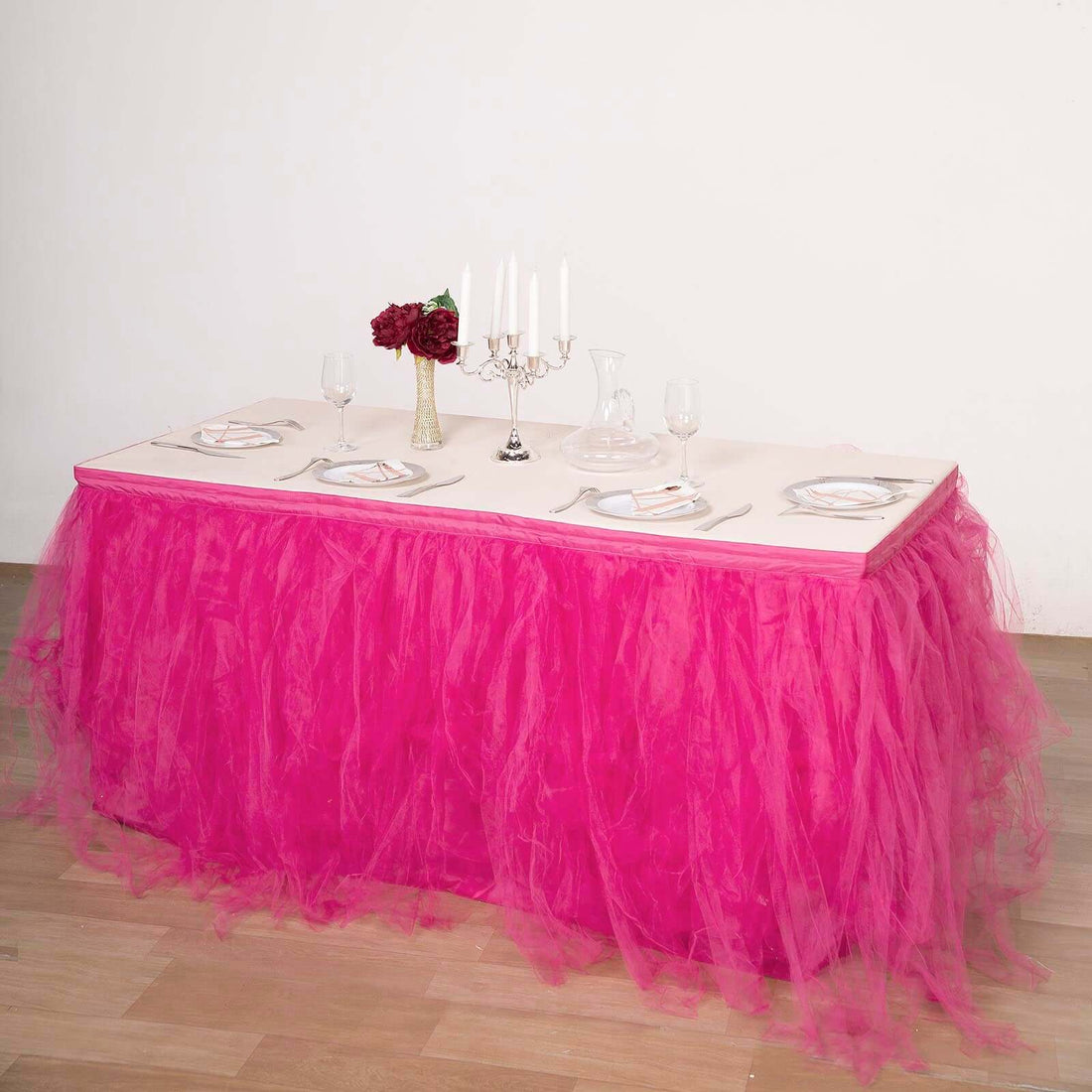 Elegant table setting with pink tulle skirt and floral centerpiece.