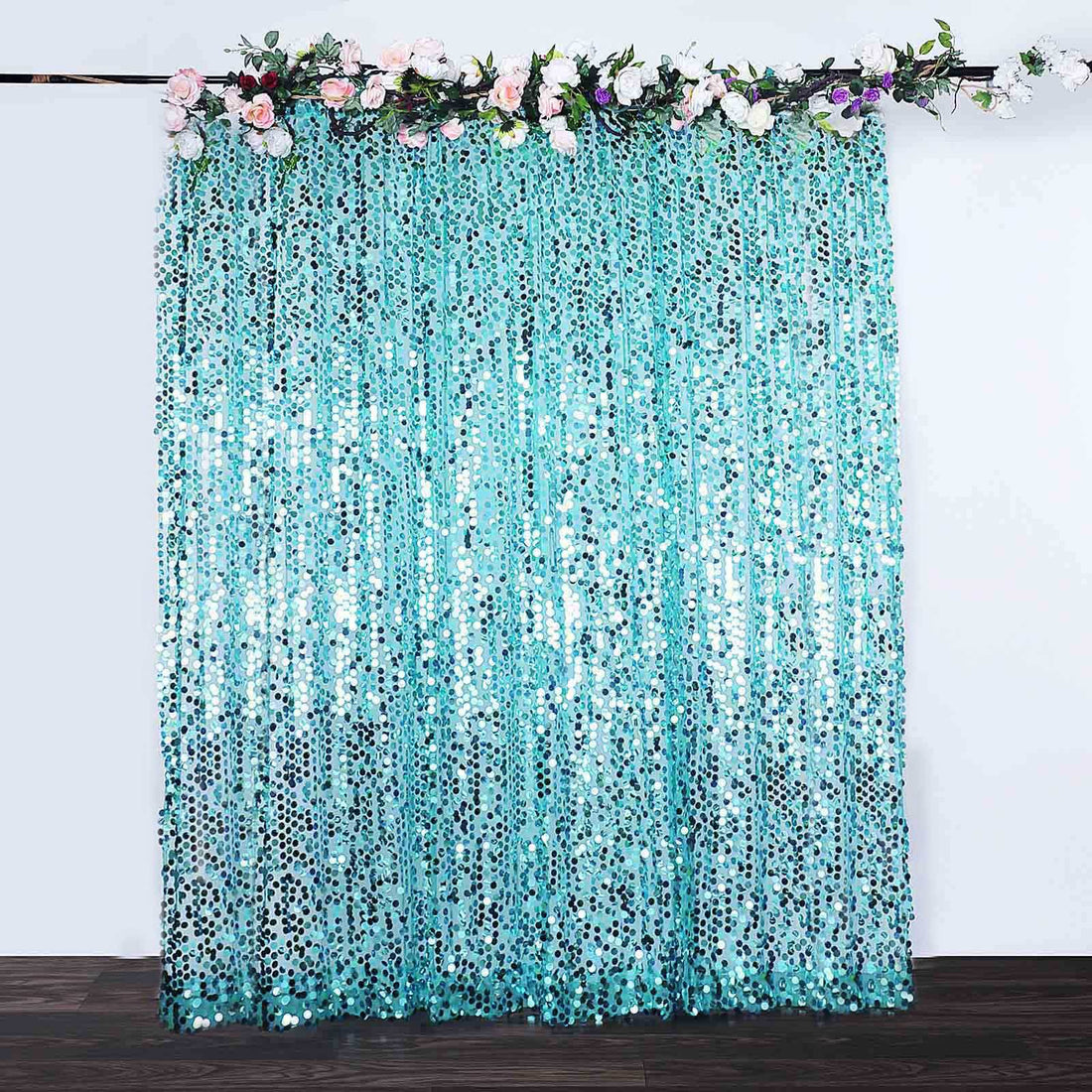 Turquoise sequin backdrop with floral accents for events and photography.