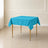 Turquoise wrinkle-resistant square tablecloth on a wooden table.