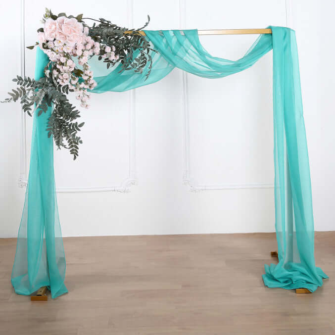 Turquoise draped fabric with floral arrangement on a wooden frame