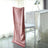 Elegant pink chair cover draped on a white chair in a bright dining setting.