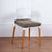 Modern chair with a white back and wooden legs, featuring a gray seat cover.