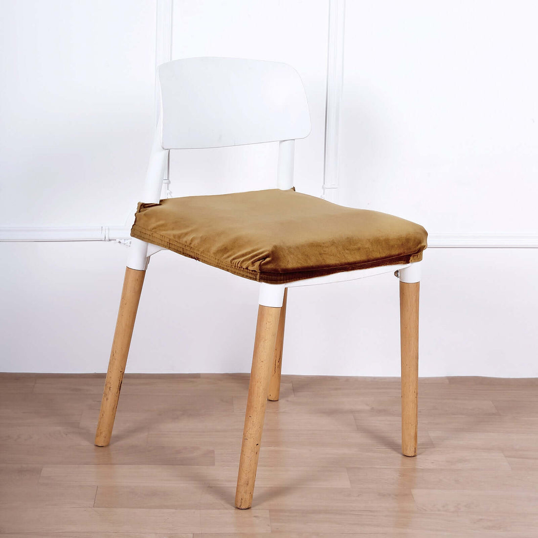 Modern white chair with wooden legs and brown velvet cushion.