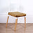 Modern white chair with wooden legs and brown velvet cushion.