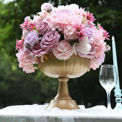Pink and purple floral arrangement in a gold vase.