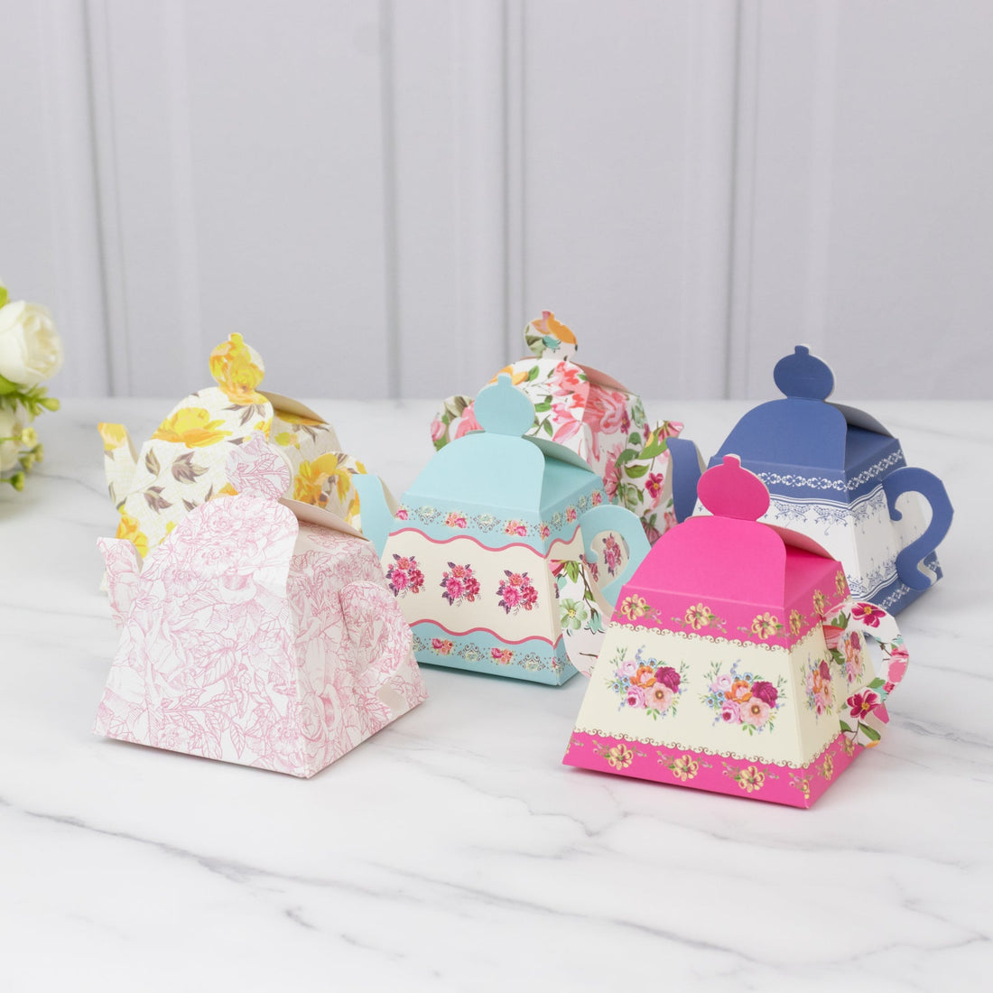 Colorful decorative tea box packaging in various floral designs.