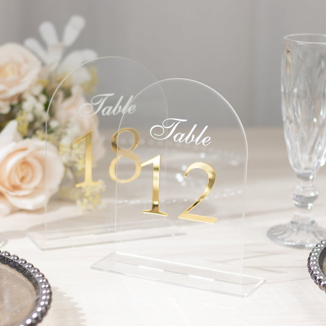 Elegant acrylic table number signs with gold accents, perfect for weddings and events.