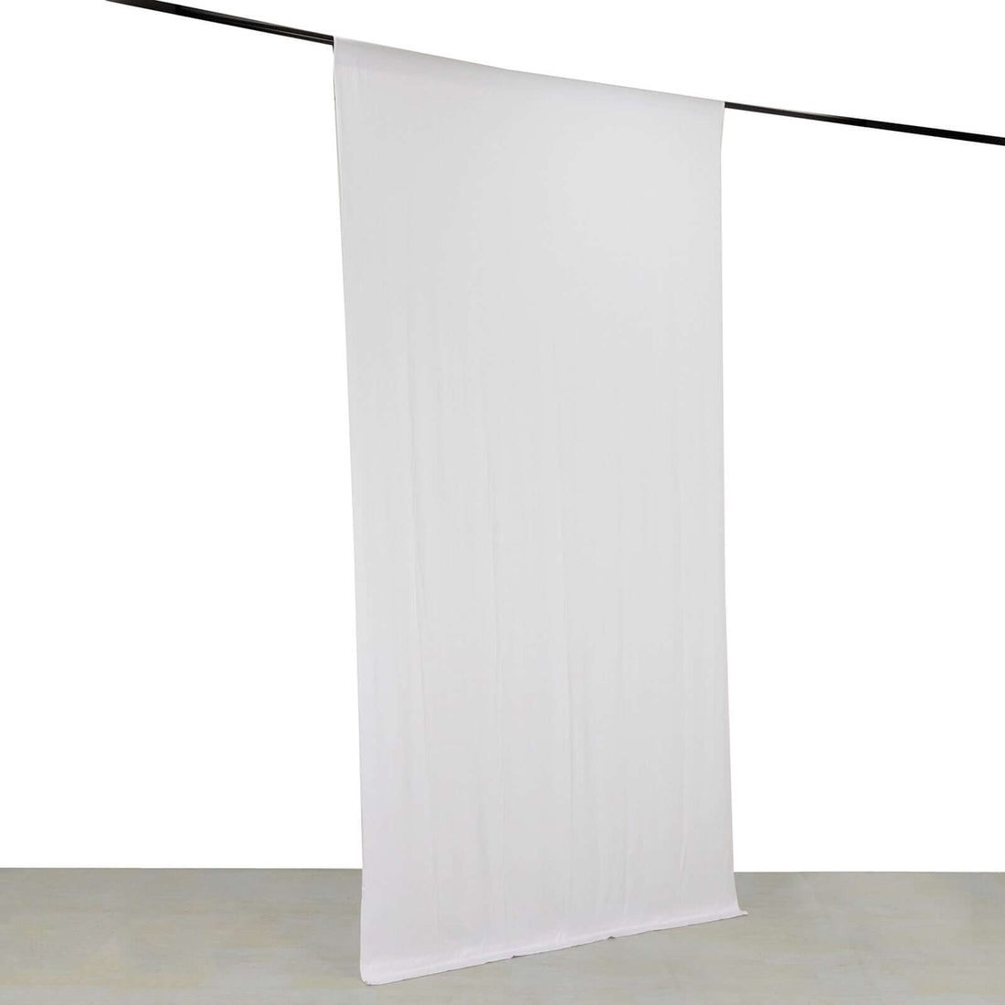 White backdrop fabric hanging from a rod for photography use.