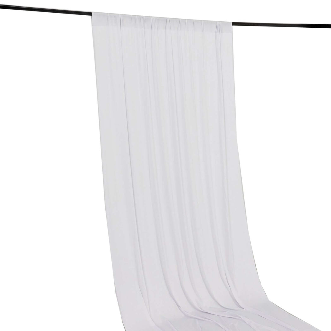 White pleated curtain hanging on a rod against a plain background
