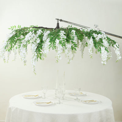 Artificial white floral chandelier above a dining table setting.