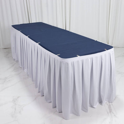 White banquet table skirt with navy table cover in a minimalist studio setting
