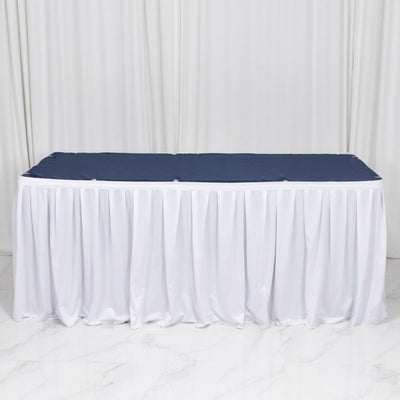 White banquet table with navy tablecloth and pleated skirt backdrop