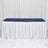 White banquet table with navy tablecloth and pleated skirt backdrop