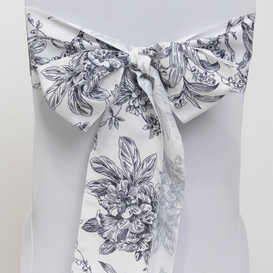 Floral patterned chair sash tied in a bow on a plain background.
