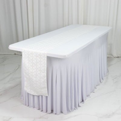 White bridal table with elegant draped tablecloth and runner on marble floor
