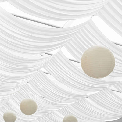 Decorative white drapery with hanging lanterns in a bright, airy setting.