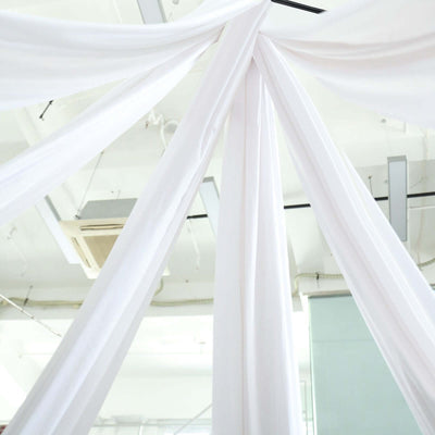 White fabric drapes hanging elegantly from a ceiling.