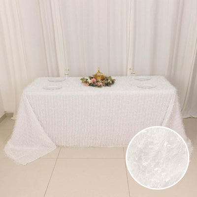 White textured tablecloth draped over a table with floral centerpiece.