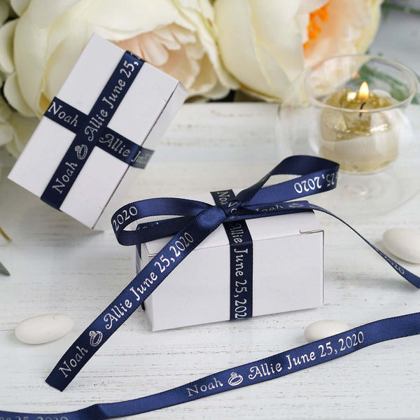 Wedding favor boxes with navy ribbons and personalized labels.
