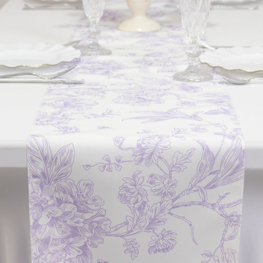 Floral table runner on a dining table with elegant glassware.