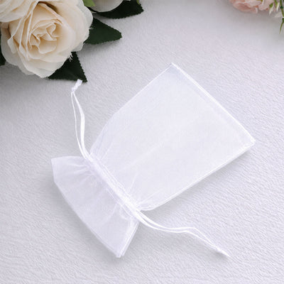 White organza gift bag with roses on soft white background