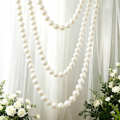 White pearl bead garland with floral backdrop for elegant wedding decor