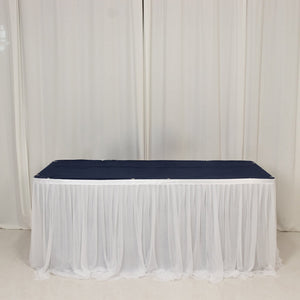 Navy table runner draped over a white tablecloth in a studio setting.