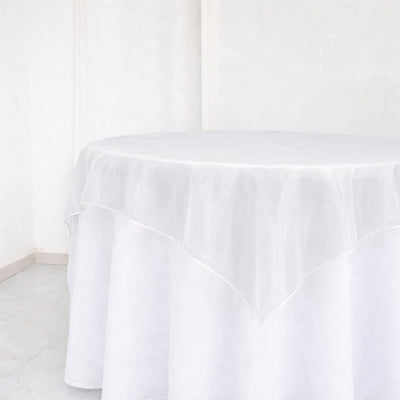 White round table with sheer tablecloth in a minimalist bright room