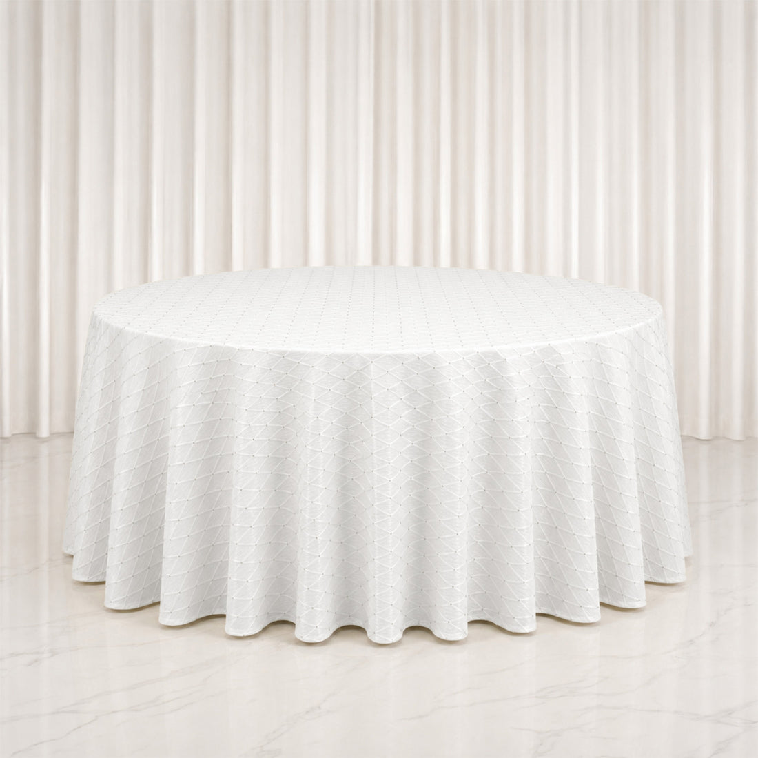 White round table with textured linen tablecloth in elegant neutral room