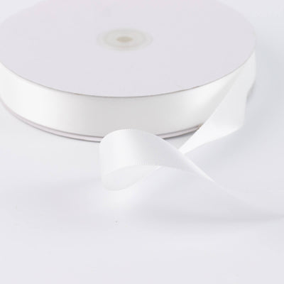 White satin ribbon spool on a white background