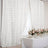Elegant white floral curtains draping over a beautifully set dining table.