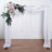 Wedding arch with floral arrangement and flowing fabric drapes