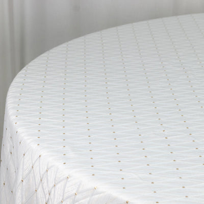White sheer tablecloth with gold polka dots draped over a round table