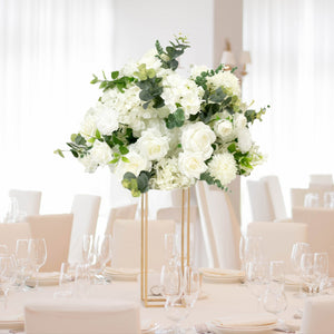 Elegant white floral centerpiece in a modern dining setting.