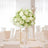 Elegant white floral centerpiece in a bright, airy dining setting.