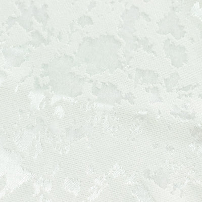 White textured fabric close-up with subtle floral pattern
