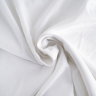 Soft white fabric with smooth texture in a swirling arrangement.