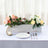 Decorative floral arrangement in a wooden planter with table setting.