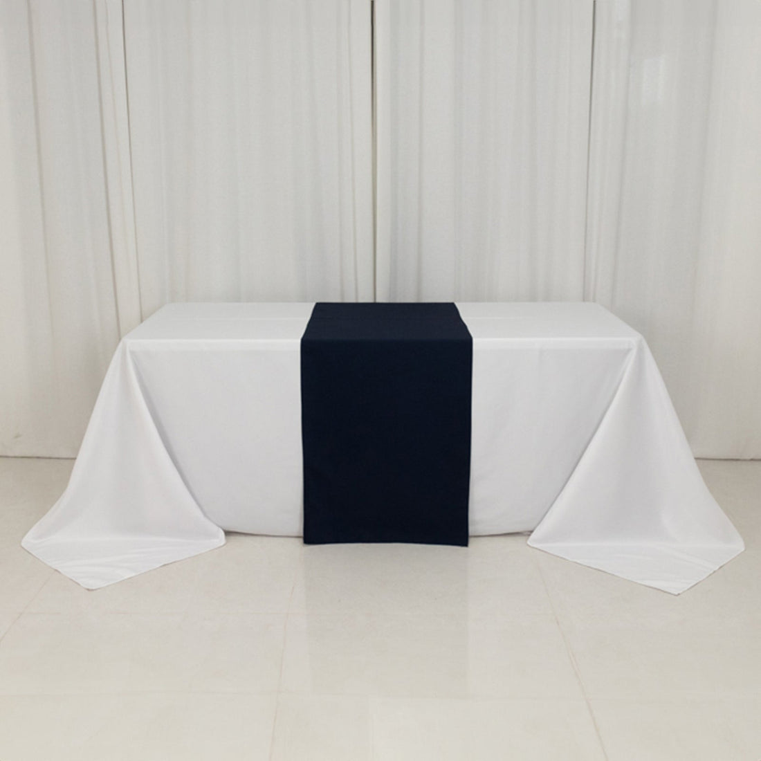 Navy table runner on white tablecloth in a minimalist setting