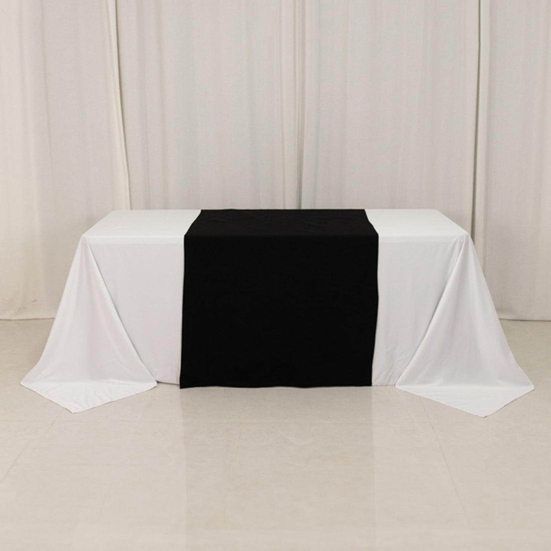 Black and white tablecloth draped over a table in studio setting