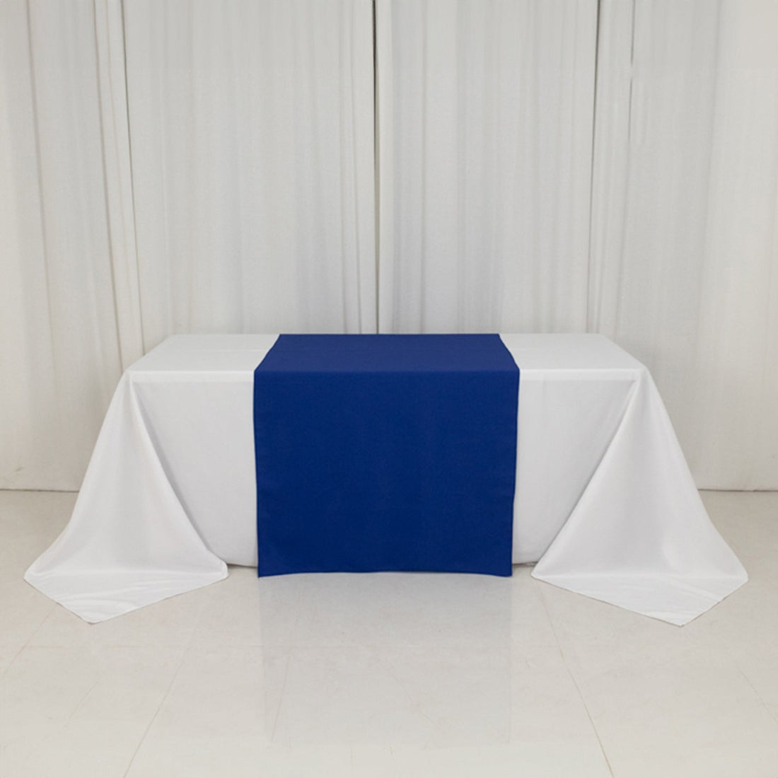 Blue table runner on a white table with draped linens