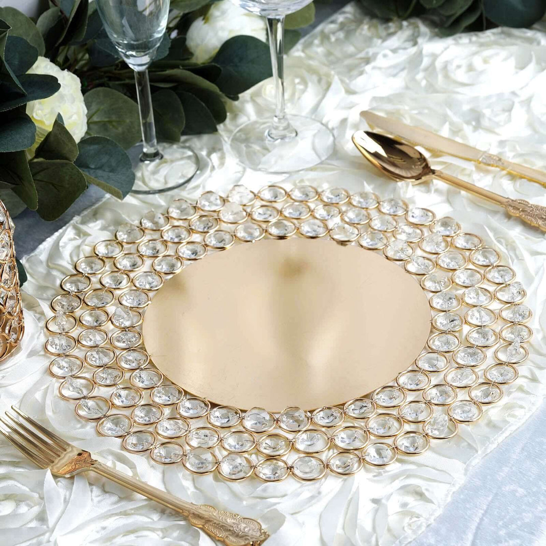 Elegant gold charger plate with crystal embellishments on a textured table setting.