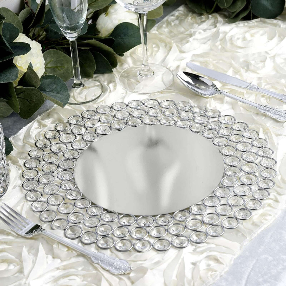 Elegant round mirrored charger plate with crystal accents for dining decor.