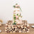 Three-tiered wedding cake adorned with flowers on a wooden stand.