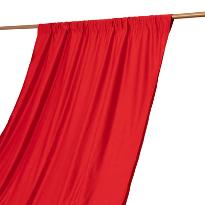 Red fabric draped on a wooden rod against a white background.
