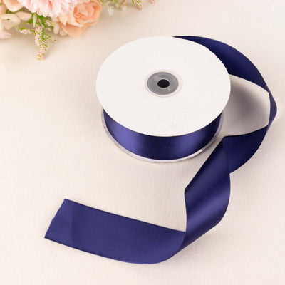 Navy satin ribbon on a spool with a loose end